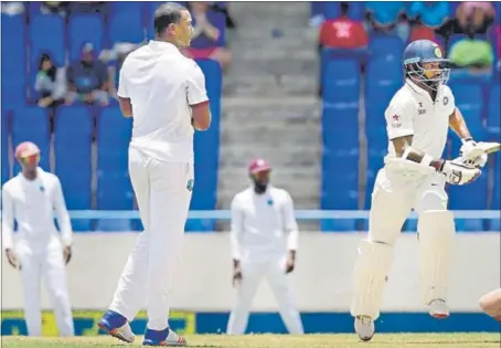  ??  ?? Shikhar Dhawan did the hard yards before settling down and helping India grab initiative during the first day of the first Test at St John’s, Antigua.