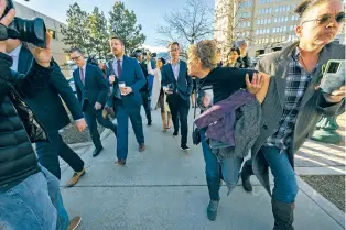  ?? CHRISTIAN MURDOCK/THE ASSOCIATED PRESS ?? Chrystina Page, right, holds back Heather De Wolf as she yells at Jon Hallford, left, the owner of Back to Nature Funeral Home, as he leaves with his lawyers following a preliminar­y hearing earlier this month in Colorado Springs, Colo. Hallford and his wife, Carie Hallford, are each charged with 190 counts of abuse of a corpse for leaving bodies to decompose at a Colorado site, and De Wolf and Page are mothers of sons believed to be among the bodies found at the funeral home.