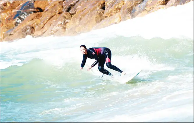  ??  ?? Meriem, a 29-year-old Moroccan engineer and surfer, surfs off the coast of Rabat.