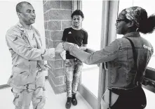  ??  ?? Principal Reginald Bush, who instilled a military-style ethos at Kashmere High, bumps fists with junior Dahjenay Whitfield.