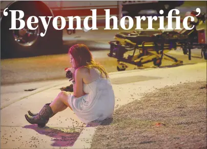  ?? "1 1)050 ?? A woman sits on a curb at the scene of a shooting outside of a music festival along the Las Vegas Strip. Multiple victims were being transporte­d to hospitals after a shooting late Sunday at a music festival.