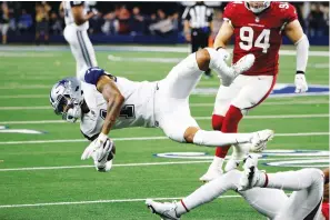  ?? The Associated Press ?? ■ Dallas Cowboys wide receiver Ced Wilson (1) is tackled after making a catch against the Arizona Cardinals during the second half of an NFL game Sunday in Arlington, Texas.