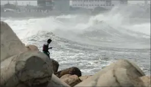  ?? (AFP) ?? A man looks out as waves hit a breakwater at Kasimedu fishing harbour in Chennai on Wednesday as Cyclone Amphan barrels towards India’s eastern coast.