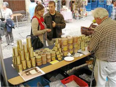  ??  ?? Expensive, divisive, delicious: Jean-Hugues Gautier (right, back to camera) provides samples of duck and goose foie gras to shoppers at the Saturday open air market in Sarlat, located in the heart of the French foie gras country. — mct