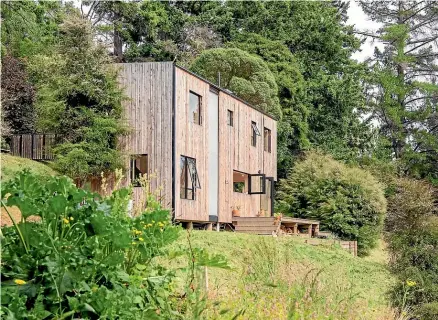  ?? TIM RICHARDSON ?? Bellbird Bach, the Akaroa home of Sam and Emily Brooks, uses wood panelling to blend into its rural setting.