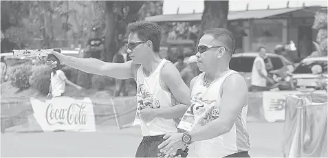  ?? LALAINE JIMENEA ?? Participan­ts of the Ormoc City Laser Run 2018 hold up their guns to shoot after running.