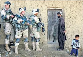  ??  ?? TWO SIDES US soldiers search an Afghan home for explosives in 2002