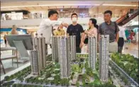  ?? LYU LIANG / FOR CHINA DAILY ?? A real estate agent (left) fields queries from prospectiv­e homebuyers at a shopping mall in Shanghai on Aug 1.