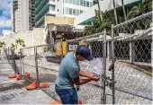  ?? PEDRO PORTAL pportal@miamiheral­d.com ?? County inspector Tadeo Monterubia­s posts a pollution violation notice in front of the Deauville.