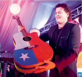  ?? FOTO ?? La decoración de la guitarra incluye las banderas de Chile y Colombia, además del logo de Carlos Vives atrás.