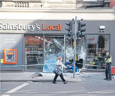  ?? Picture: SWNS. ?? Police outside a branch of Sainsbury’s on Shandwick Place in Edinburgh, where thieves believed to be in an Audi stolen from Fife tried to steal an ATM.