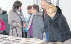  ?? FOTO: SABINE RÖSCH ?? Mit Interesse betrachten die Besucher die historisch­en Aufnahmen aus den Beständen von Pfarrer Traub.