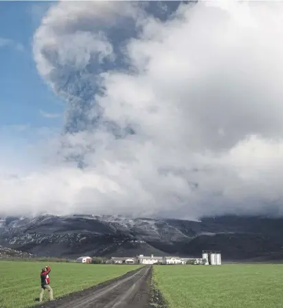  ?? ?? Dark ash clouds from the erupting Eyjafjalla­jökull volcano rise in the distance above a farm in 2010. Huge numbers of planes were grounded as a result of the eruption