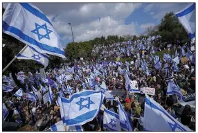  ?? (AP/Ohad Zwigenberg) ?? Israelis wave national flags during a protest Monday outside the Knesset, Israel’s parliament, in Jerusalem. More photos at arkansason­line.com/214protest/.