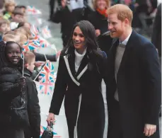  ?? CITIZEN NEWS SERVICE PHOTO BY MATT DUNHAM ?? In this Thursday, March 8, 2018 file photo, Britain’s Prince Harry and his fiance Meghan Markle are greeted by flag waving school children as they arrive to take part in an event for young women as part of Internatio­nal Women’s Day in Birmingham,...