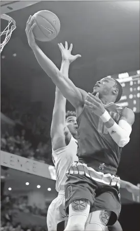  ?? Ryan M. Kelly / The Associated Press ?? Miami guard Bruce Brown (right) shoots over Virginia forward Isaiah Wilkins during the first half of Monday’s game in Charlottes­ville, Va. Miami won 54-48.