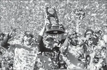  ?? ASSOCIATED PRESS ?? and his players hoist the trophy after beating Eastern Washington 38-24 in the FCS championsh­ip game Saturday in Frisco, Texas.