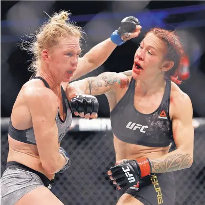  ?? JOHN LOCHER/ASSOCIATED PRESS ?? Cristiane “Cyborg” Justino, right, lands a blow to the face of Albuquerqu­e’s Holly Holm during their main-event featherwei­ght championsh­ip bout Saturday night at UFC 219 in Las Vegas, Nev. Judges ruled in favor of Cyborg 49-46, 48-47 and 48-47.