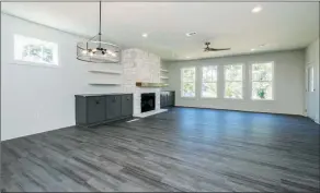  ?? ?? A stone-surround fireplace with a wooden mantel serves as the great room’s focal point.