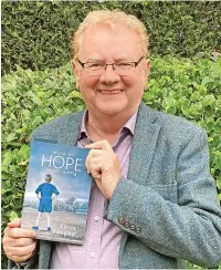  ?? ?? ● Chris holding his book titled More in Hope Than Glory