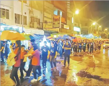  ?? — Photo by Raymond Tan ?? Participan­ts of the parade continue on, despite heavy rain.