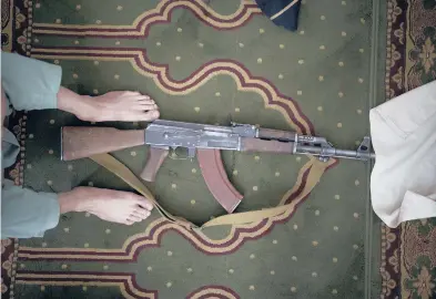  ?? FELIPE DANA/AP ?? A Taliban fighter lays his AK-47 rifle down during Friday prayers on Sept. 10 at a mosque in Kabul, Afghanista­n.