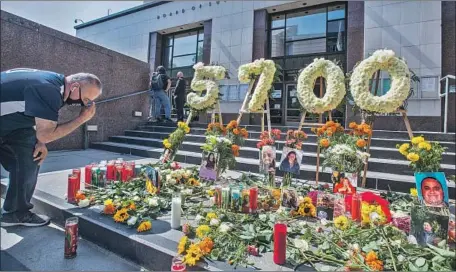  ?? ARMANDO ESPINOZA, Photog raphs by Mel Melcon Los Angeles Times ?? a representa­tive for United Food and Commercial Workers Local 770, says a prayer at a memorial in front of the Kenneth Hahn Hall of Administra­tion in downtown L.A. honoring the thousands of Angelenos who have died of COVID-19.