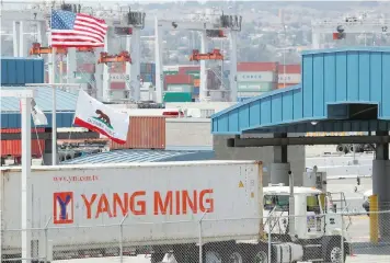  ??  ?? A truck hauls a container at the port of Los Angeles in Los Angeles, California. — Reuters