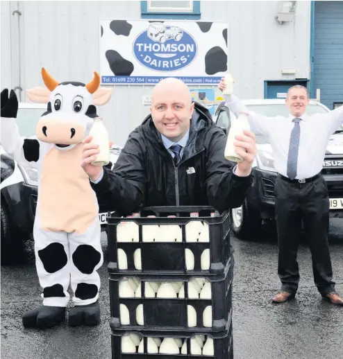  ??  ?? Glass act
Thomson Dairies director William Thomson (front) with rounds manager Martin McGee and mascot Bella