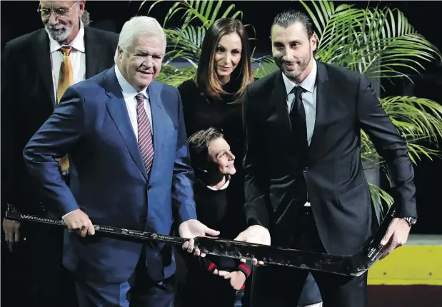  ?? — THE ASSOCIATED PRESS ?? Panthers goalie and former Canuck Roberto Luongo is presented with a gold-covered hockey stick by Florida GM Dale Tallon before Saturday’s game against Vancouver in Sunrise, Fla. Luongo was honoured for reaching his 1,000th NHL game last spring.