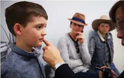  ??  ?? At the Tibooburra clinic, six-year-old Edward Hill, with mum Rachel and brother Ethan, 9, has a consultati­on with an RFDS doctor.