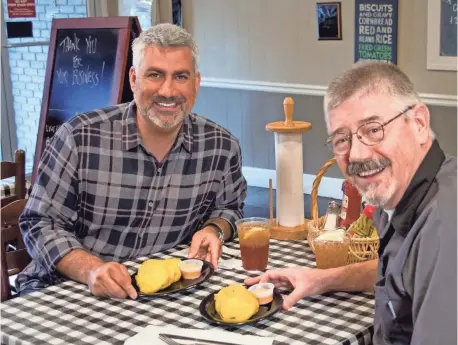  ?? INSP.COM ?? Singer Taylor Hicks, left, and Irondale Café owner Jim Dolan sit down for some fried green tomatoes. The signature treats at the café, near Birmingham, Ala., are so good that a book and a movie were named for them.