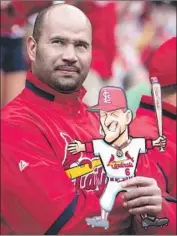  ?? Jeff Roberson Associated Press ?? ALBERT PUJOLS, then with the St. Louis Cardinals, holds a cartoon cutout of former Cardinals great Stan Musial as Musial is honored by the team in 2010.