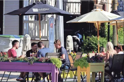  ?? RICK WOOD/MILWAUKEE JOURNAL SENTINEL ?? Diners enjoy conversati­on and a few summer drinks Thursday outside Dorsia on Brady Street. Many restaurant­s are expanding outdoors through the Active Streets for Business Program.