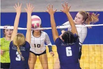  ?? GREG SORBER/JOURNAL ?? Volcano Vista’s Olivia Dixson, right, hits as La Cueva’s Rebecca Leischner (3) and Maalese Wallace (6) go up for a block. The Bears won in four sets in the Class 5A semifinals.