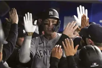  ?? The Canadian Press via AP / CHRIS YOUNG photo ?? The Yankees’ Aaron Judge is congratula­ted for his two-run home run during the eighth inning of New York’s 6-3 win over the Blue Jays on Tuesday.