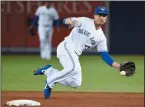  ?? THE CANADIAN PRESS/NATHAN DENETTE ?? Toronto Blue Jays shortstop Darwin Barney (18) makes a diving play on a ground ball hit by Tampa Bay Rays shortstop Adeiny Hechavarri­a (11) during ninth inning AL baseball action in Toronto on Wednesday.