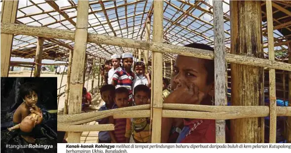  ??  ?? Kanak-kanak Rohingya melihat di tempat perlindung­an baharu diperbuat daripada buluh di kem pelarian Kutupalong berhampira­n Ukhia, Bangladesh.