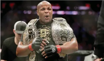  ?? JULIO CORTEZ/THE ASSOCIATED PRESS ?? Daniel Cormier holds his belts after defeating Derrick Lewis by submission in the second round of their heavyweigh­t mixed martial arts bout at UFC 230 Sunday in New York.