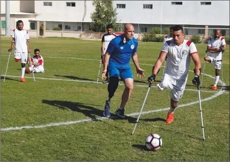  ?? (AP/Adel Hana) ?? Coach Simon Baker, an Internatio­nal Committee of the Red Cross consultant and founder of the Irish Amputee Football Associatio­n, trains amputee players of the first Palestinia­n national team for amputee football Dec. 5 at Palestine Stadium in Gaza City.