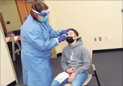  ??  ?? Dr. Susan Glasman administer­s a COVID-19 test to Luciano Warner, of Meriden, at the new testing site on the University of Connecticu­t Stamford campus on Thursday.