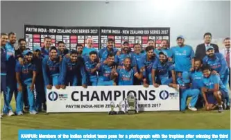  ?? — AFP ?? KANPUR: Members of the Indian cricket team pose for a photograph with the trophies after winning the third and final One day internatio­nal (ODI) cricket match between India and New Zealand, at the Green Park Cricket Stadium in Kanpur .