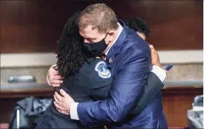  ?? Andrew Harnik / Associated Press ?? Former U.S. Capitol Police Chief Steven Sund, right, hugs Capitol Police Capt. Carneysha Mendoza, left, before they testify before a Senate Homeland Security and Government­al Affairs & Senate Rules and Administra­tion joint hearing on Capitol Hill on Tuesday.