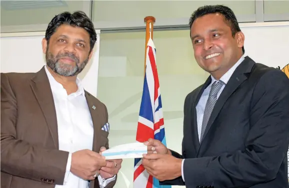  ?? Photo: Ronald Kumar ?? Attorney-General and Minister for Economy Aiyaz Sayed-Khaiyum receives a $10,000 cheque from Fiji Institute of Accountant­s president Nitesh Lal for the Prime Minister’s COVID-19 fund.