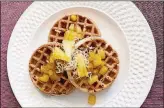  ?? LAUREN J. MAPP/THE SAN DIEGO UNION-TRIBUNE/TNS ?? Gold, crispy Pina Colada Waffles incorporat­e pineapple, toasted coconut and hazelnuts, with a topping of pineapple sauce for a warm, flavorful bite.