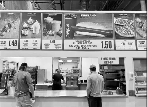  ?? SHUTTERSTO­CK. COM ?? Customers wait in line at the Costco food court, where the quarter-pound hot dog special still costs the same as it did when it was introduced in the 1980s.