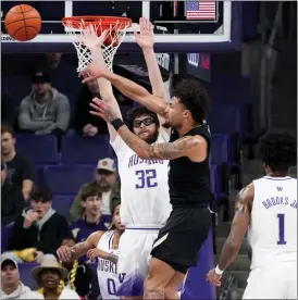  ?? LINDSEY WASSON — THE ASSOCIATED PRESS ?? Colorado’s J’vonne Hadley, center, passes the ball past Washington forward Wilhelm Breidenbac­h, left, during the first half of Wednesday’s game in Seattle.