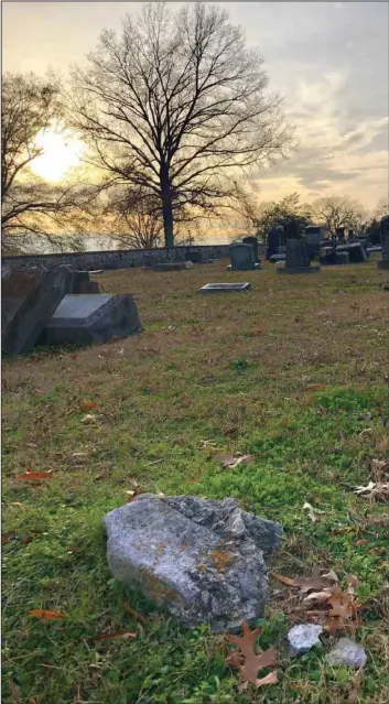  ?? (Arkansas Democrat-Gazette/Celia Storey) ?? Souvenir hunters chipped chunks off the grave marker of notorious bandit Tom Slaughter (1896-1921) until all that remains is this chunk of stone at Oakland Fraternal Cemetery in Little Rock, photograph­ed near sunset Dec. 7.