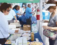  ??  ?? Cultural assistant Maya Cruz (left) served coconut wraps with coco jam to festival visitors.