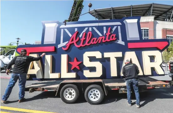  ?? JOHN SPINK/AP ?? Workers load an All-Star sign onto a trailer after it was removed from Truist Park in Atlanta on Tuesday. MLB is relocating the All-Star Game to Coors Field in Denver.